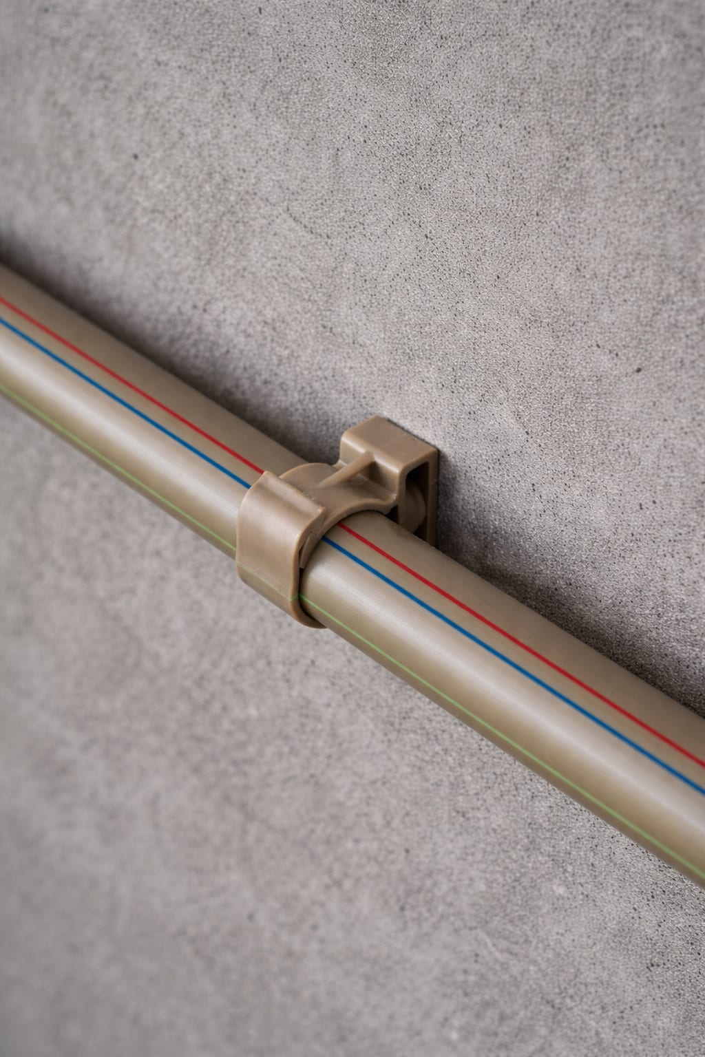 UNITWIST EasyBat clip system securing a pipe to a wall on a job site